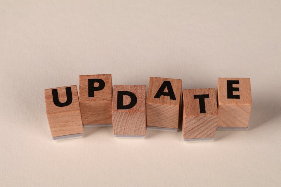 Wooden letter blocks arranged to spell 'Update' on a beige surface.